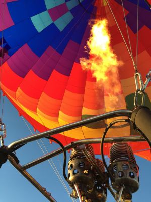 炎を噴き上げながら空を舞う、カラフルな熱気球