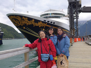 アラスカのスキャグウェイにて、下船した際にディズニー・ワンダー号をバックに記念撮影。家族みんなで防寒具完璧です！（左から、稲田須美子さん、あづみさん、ともさん）