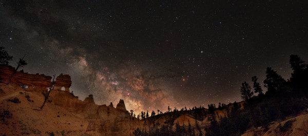 Milky Way Galaxy surrounded by hoodoos and ponderosa pine at the Mossy Cave Trail. Photo by Derek Demeter "Galactic Frontier" BRCA AstroFest 2015 Courtesy of www.NPS.gov